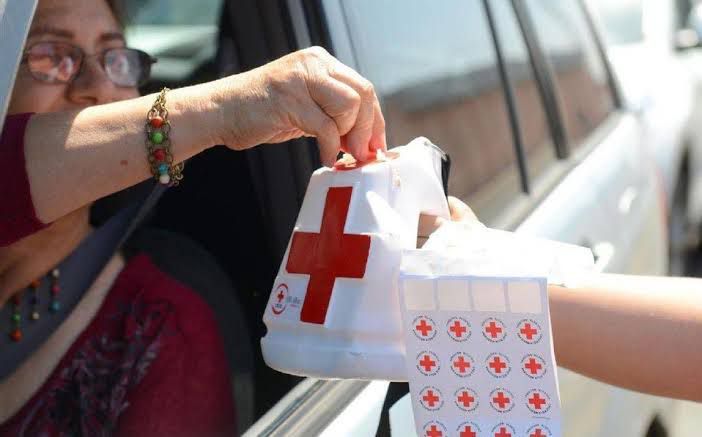 Mujer cooperando desde su vehículo para la colecta de la Cruz Roja