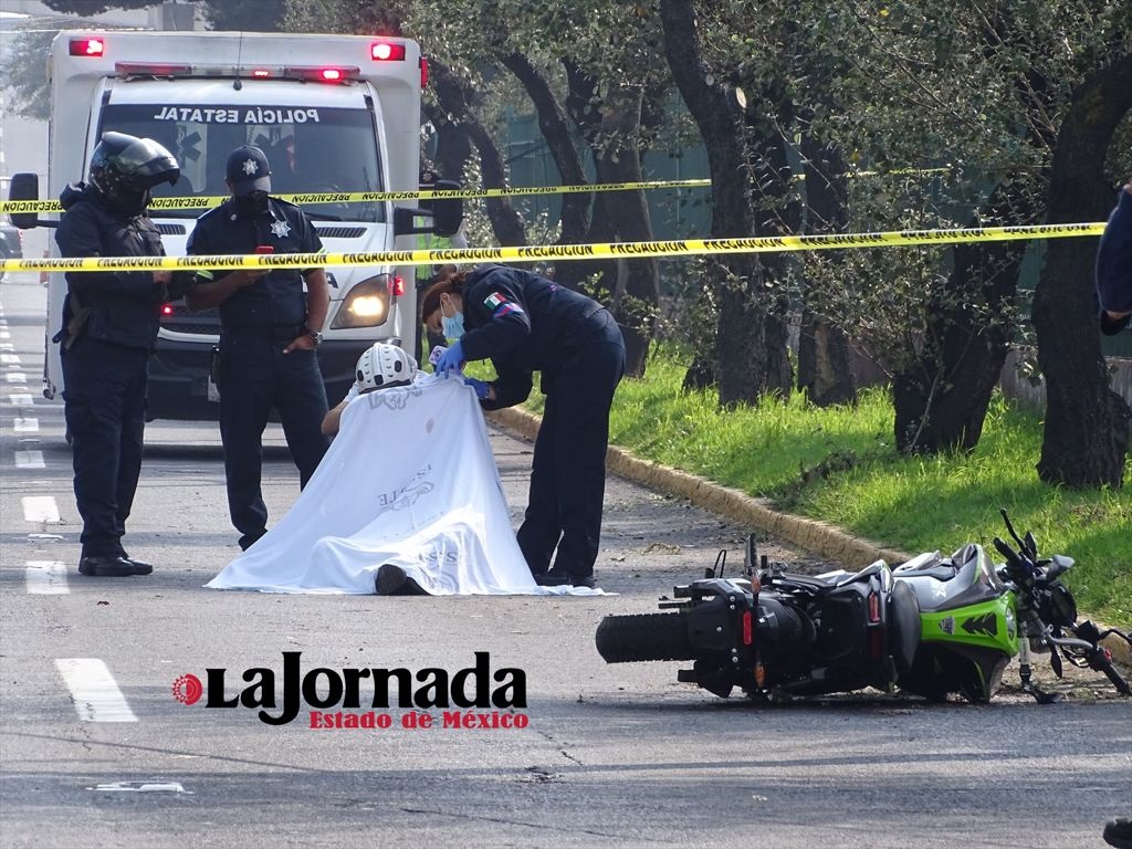 cuerpo de motociclista cubierto, elementos de seguridad pública resguardan la zona